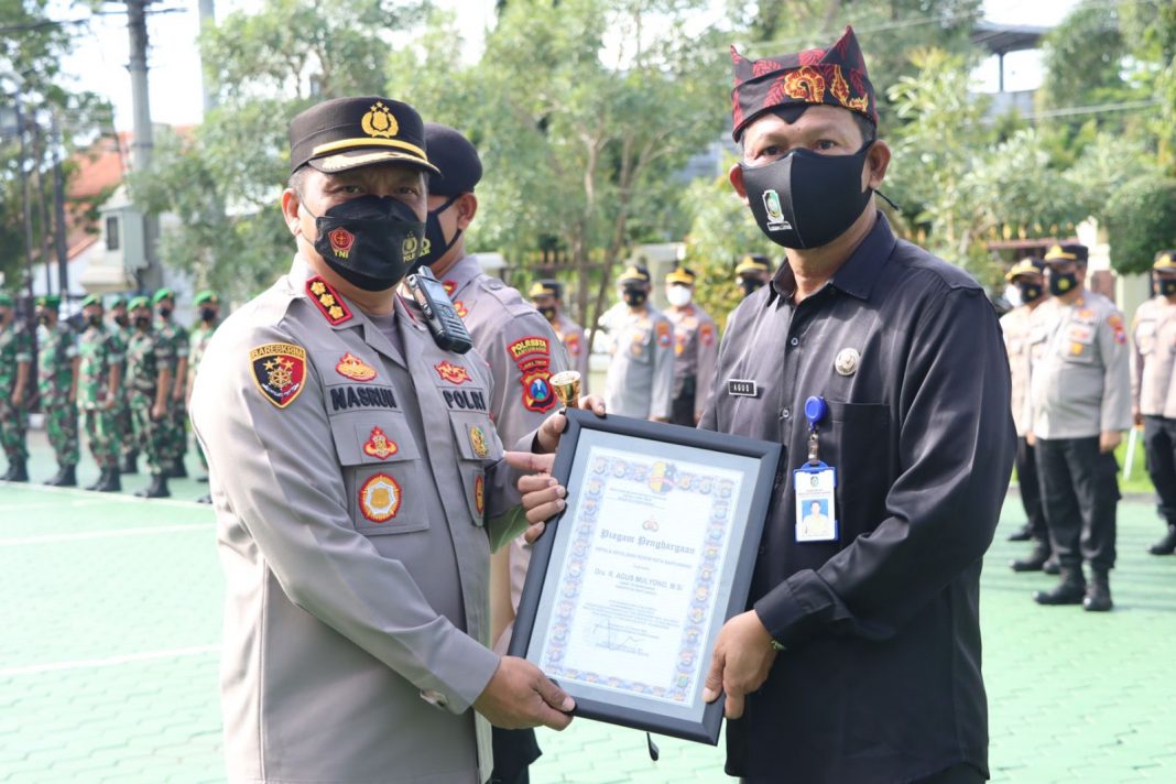 Kapolresta Banyuwangi Kombespol Nasrun Pasaribu menyerahkan penghargaan kepada Camat Pesanggaran, Kamis (24/2/2022) pagi.