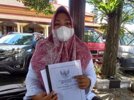 Mantan Bendahara Desa Sumberberas, Kecamatan Muncar, Banyuwangi Gilang Intan Purnama Sari menunjukkan berkas LPJ APBDes 2021 di Polresta Banyuwangi, Senin (4/4/2022).