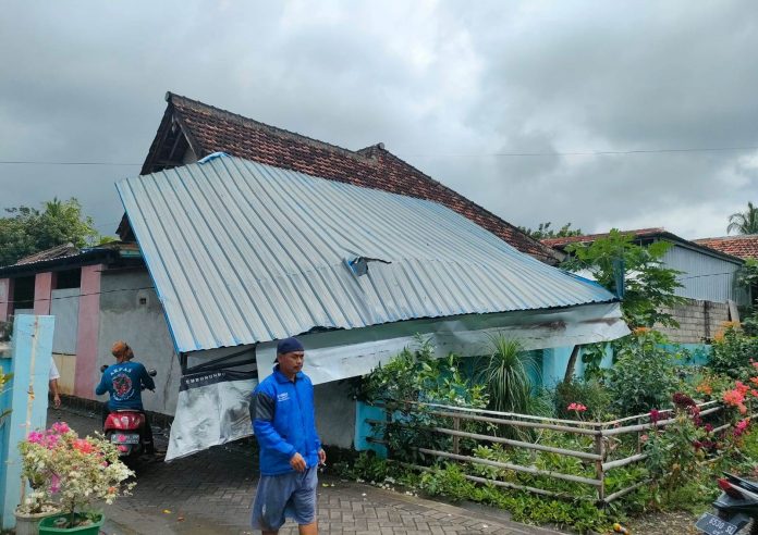 WhatsApp Image 2022-09-15 at 12.31.43 Warga Desa Tampo, Kecamatan Cluring, Banyuwangimembersihkan atap rumah yang jebol akibat terjangan puting beliung, Kamis (15/9/2022) siang.