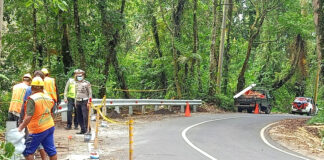 Petugas Kepolisian memasang pagar pengaman di jalur maut menuju wisata Kawah Ijen, Banyuwangi.