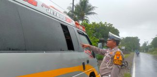 Polisi menunjukkan kaca jendela yang digunakan melompat penumpang travel di Jalan Raya Kalibaru, Banyuwangi, Kamis (11/5/2023) pagi. (foto/udi)