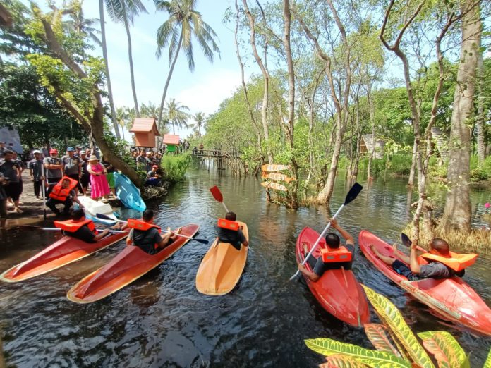 Wisatawan menikmati permainan kano di obyek wisata Cacalan, Banyuwangi. (foto/ist)