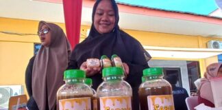 Seorang ibu nelayan di Muncar, Banyuwangi menunjukkan produk sabun cair berbahan rumput laut., Minggu (30/7/2023). (foto/udi)