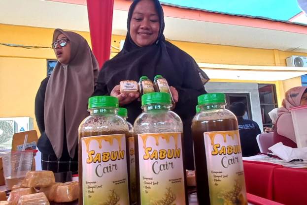 WhatsApp Image 2023-07-31 at 12.29.58 Seorang ibu nelayan di Muncar, Banyuwangi menunjukkan produk sabun cair berbahan rumput laut., Minggu (30/7/2023). (foto/udi)