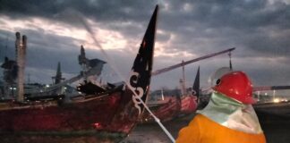 Petugas Damkar memadamkan api yang melalap perahu di dermaga Muncar, Banyuwangi, Senin (11/9/2023) malam. (foto/ist)