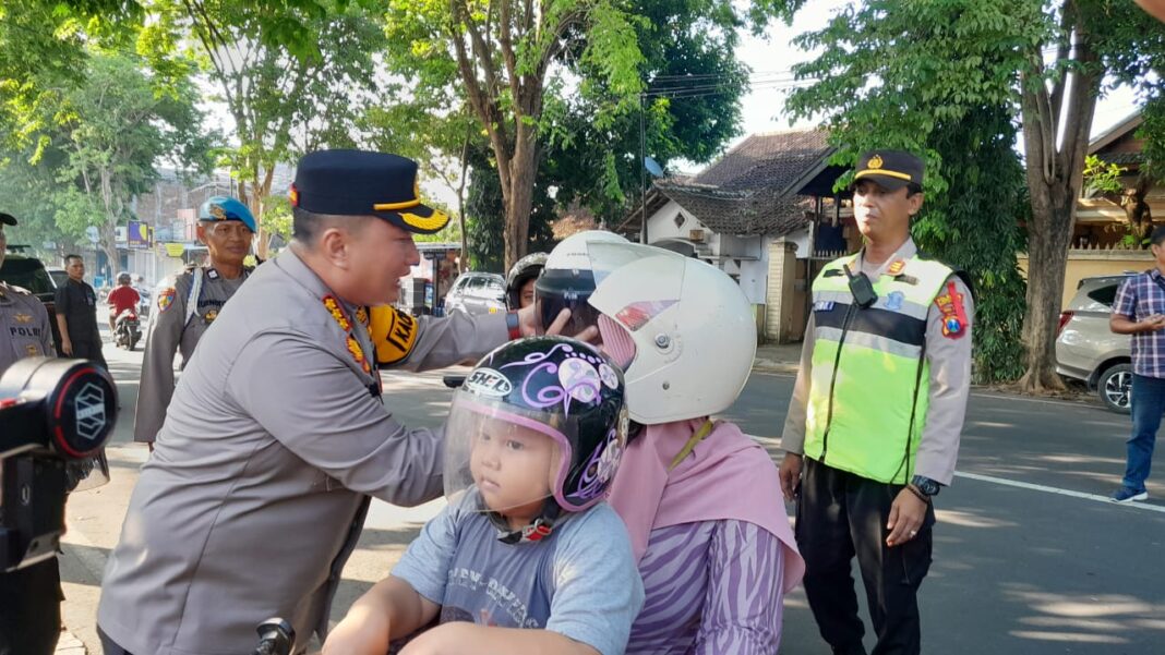 WhatsApp Image 2024-03-19 at 06.30.20 Kapolresta Banyuwangi, Kombes Pol Nanang Haryono membagikan helm kepada siswa SDN 1 Mojopanggung, Kecamatan Giri, Selasa (19/3/2024). (Foto/udi)