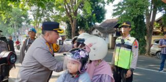 Kapolresta Banyuwangi, Kombes Pol Nanang Haryono membagikan helm kepada siswa SDN 1 Mojopanggung, Kecamatan Giri, Selasa (19/3/2024). (Foto/udi)