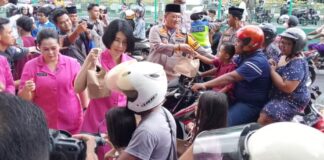 Kapolresta Banyuwangi Kombes Pol. Nanang Haryono bersama Ketua Cabang Bhayangkari membagikan takjil ke pengendara motor, Kamis (21/3/2024). (Foto/udi)