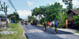 Petugas Dinas PU Cipta Karya dan Penataan Ruang (PU CKPR) Banyuwangi mengerjakan perbaikan jalan, Senin (1/4/2024). (Foto/ist)