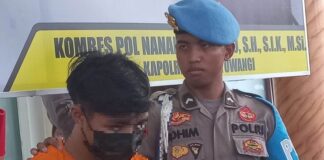 Salah satu terduga pelaku sindikat peredaran narkoba di Banyuwangi dengan barang bukti 6,1 kilogram sabu diamankan ke Polresta Banyuwangi, Jumat (5/4/2024). (Foto/udi)