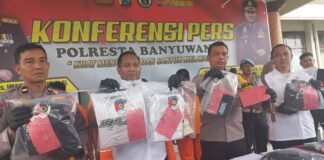 Wakapolresta Banyuwangi AKBP Dewa Putu Darmawan bersama Kasat Reskrim Kompol Andrew Vega menunjukkan barang bukti pengeroyokan pesilat, Rabu (24/4/2024). (Foto/udi)