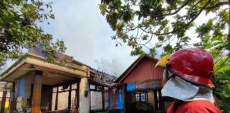 Petugas pemadam menjinakkan api yang membakar sebuah rumah di Kelurahan Penataban, Kecamatan Giri, Banyuwangi, Jumat (24/5/2024). (Foto/ist)