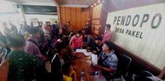Warga Desa Pakel, Kecamatan Licin, Banyuwangi antre menerima tali asih dari Perkebunan Bumisari, Minggu (26/5/2024). (Foto/udi)