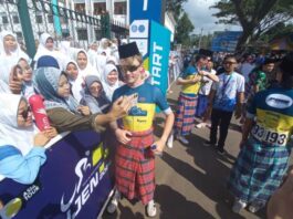 Pembalap asing TdBI 2024 menggunakan sarung dan songkok berfoto bersama warga di start etape pertama, Senin (22/7/2024). (Foto/udi)