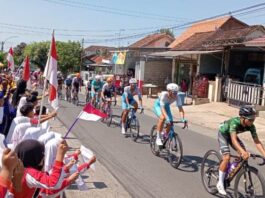 Para pelajar di Desa Kemiren, Banyuwangi menyambut para pembalap etape 4 TdBI, Kamis (25/7/2024). (Foto/udi)