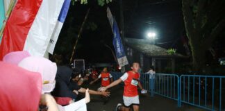 Warga menyambut pelari dalam even Banyuwangi Night Run di Maroon, Genteng, Banyuwangi, Sabtu (10/8/2024) malam. (Foto/Humas Pemkab Banyuwangi)