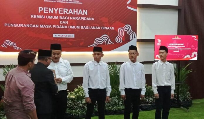 Sekkab Banyuwangi Mujiono didampingi Kalapas Agus Wahono menyerahkan remisi kepada warga binaan serangkaian Hari Kemerdekaan RI ke-79, Sabtu (17/8/2024). (Foto/udi)