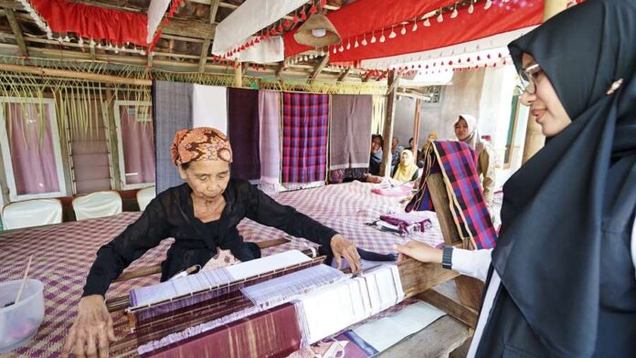Perajin tenun tradisional di Desa Jambesari, Kecamatan Giri, Banyuwangi sedang mengerjakan kain. (Foto/Humas Pemkab Banyuwangi)