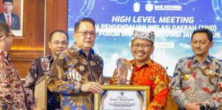 Pj Bupati Banyuwangi Sugirah menerima penghargaan Pengendali Inflasi Daerah (TPID) dari Pemprov Jatim. (Foto/Humas Pemkab Banyuwangi)