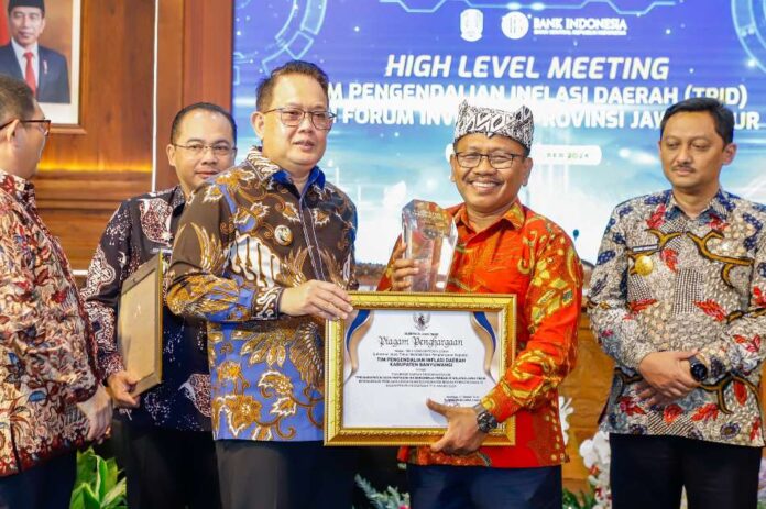 TPID Pj Bupati Banyuwangi Sugirah menerima penghargaan Pengendali Inflasi Daerah (TPID) dari Pemprov Jatim. (Foto/Humas Pemkab Banyuwangi)