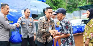Kepala Lapas Banyuwangi Mochamad Mukaffi menyerahkan bantuan sembako kepada warga di Polsek Licin, Sabtu (25/1/2025). (Foto/Lapas Banyuwangi)