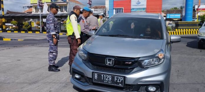 Personel Polresta Banyuwangi bersama TNI melakukan pemeriksaan kendaraan di pintu masuk Pelabuhan Ketapang, Selasa (28/1/2025). (Foto/Humas Polresta Banyuwangi)