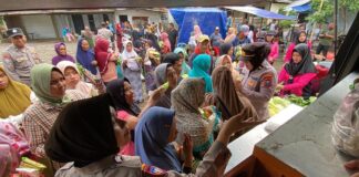 Ibu-ibu di Desa Segobang, Kecamatan Licin mendapatkan sayuran gratis dari Polresta Banyuwangi, Jumat (31/1/2025). (Foto/udi)