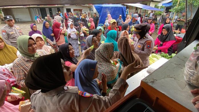 Ibu-ibu di Desa Segobang, Kecamatan Licin mendapatkan sayuran gratis dari Polresta Banyuwangi, Jumat (31/1/2025). (Foto/udi)