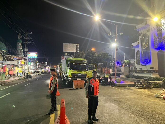 antrean Personel Polresta Banyuwangi siaga penuh di jalur antrean menuju Pelabuhan Ketapang, Banyuwangi, Rabu (23/7/2025) malam. (Foto/ist)