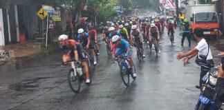 Pembalap TdBI 2025 melaju di tengah guyuran hujan lebat pada etape ketiga, Rabu (30/7/2025). (Foto/udi)