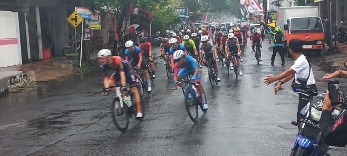 etape 3 Pembalap TdBI 2025 melaju di tengah guyuran hujan lebat pada etape ketiga, Rabu (30/7/2025). (Foto/udi)