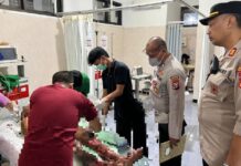 Personel Polsek Gambiran, Banyuwangi mendampingi pasutri yang terbakar di RSUD Genteng, Jumat (24/4/2026) malam. (Foto/ist)