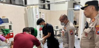 Personel Polsek Gambiran, Banyuwangi mendampingi pasutri yang terbakar di RSUD Genteng, Jumat (24/4/2026) malam. (Foto/ist)